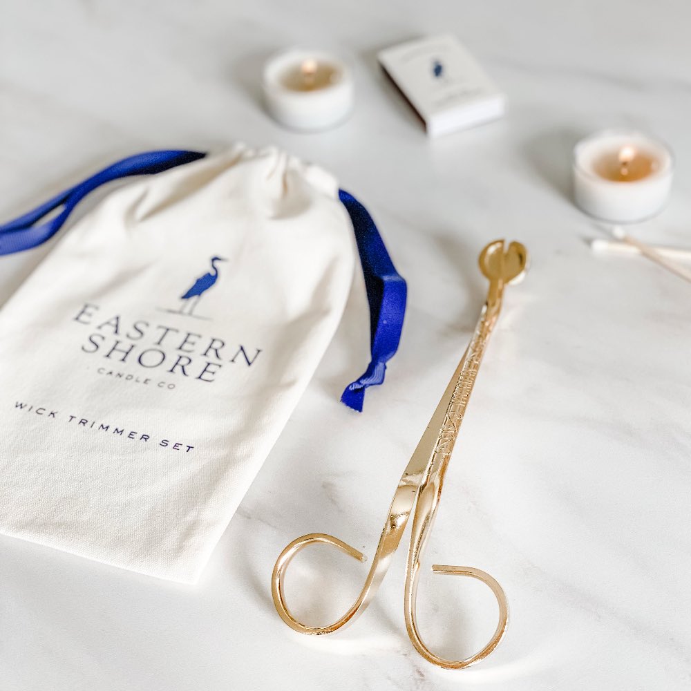 Gold wick trimmer set with Eastern Shore Candle Co drawstring bag on a light background