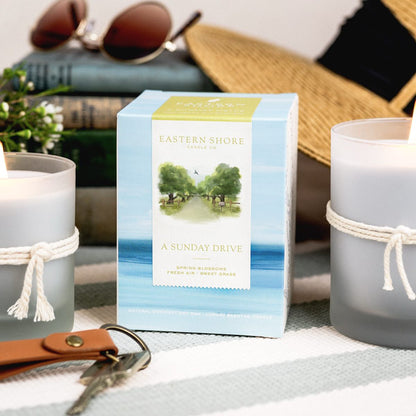 A Sunday Drive 10oz candle box with candle to the side, Eastern Shore Co. hand poured in very small batches, Scented candle, coconut soy wax, coastal candle, eastern shore, Chesapeake Bay, luxury candle, hand-poured, Maryland, Virginia, candle gift, coastal gift, Spring candle scents, spring scents, floral candle, floral scents, Sunday Drive, spring blossoms, sweet grass, fresh air, spring air, honeysuckle scent