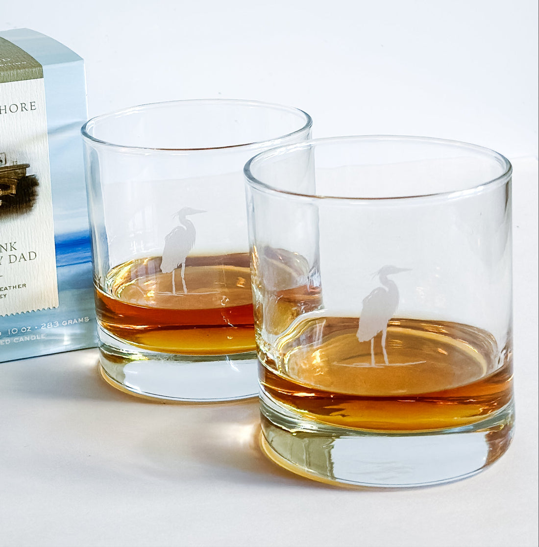 Candle, two glasses with liquid, and a box labeled &