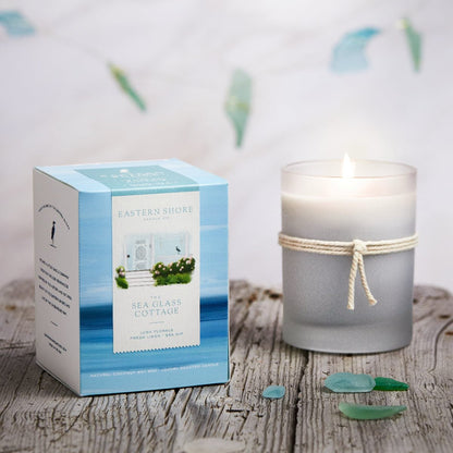 The Sea Glass Cottage candle - coconut soy wax - cottage garden scent, seaside garden, geranium, jasmine, gardenia, roses, lily, magnolia, peony, seaside air, sea breeze, Scented candle, coastal candle, eastern shore, Chesapeake Bay, luxury candle, hand-poured, Maryland, Virginia, 10 oz candle with box on a wooden table