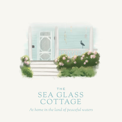 The Sea Glass Cottage candle illustration graphic.  Showing heron on the front railing on the garden home.   - coconut soy wax candle - cottage garden scent, seaside garden, geranium, jasmine, gardenia, roses, lily, magnolia, peony, seaside air, sea breeze, Scented candle, coastal candle, eastern shore, Chesapeake Bay, luxury candle, hand-poured, Maryland, Virginia