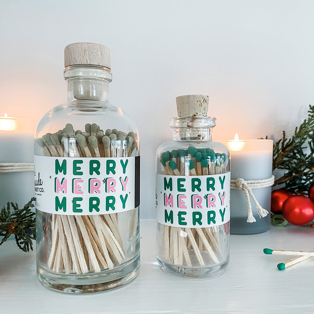 Two glass bottles with cork lids containing matches, labeled &